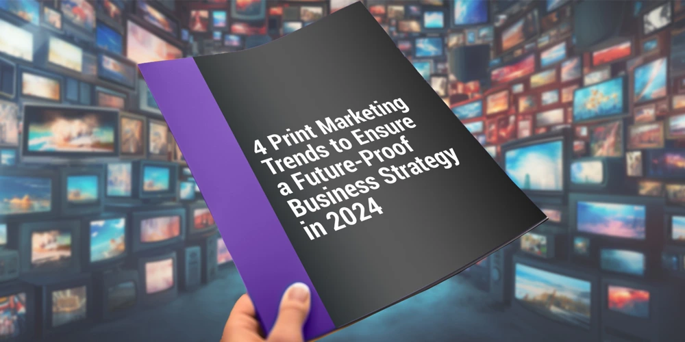 A hand holding a pamphlet that reads 4 Print Marketing Trends to Ensure a Future-Proof Business Strategy in 2024